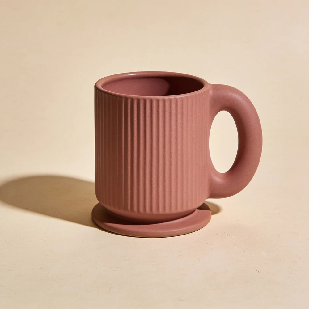 Fluted clay-pink ceramic mug with a broad foot ring and rounded loop handle