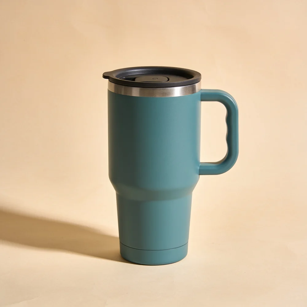 Double-wall muted teal stainless steel tapered travel tumbler with large full D handle, flat black polymer press-on drinking lid attached, no straw